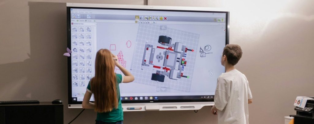 Kids learning with an interactive board in a modern classroom setting.